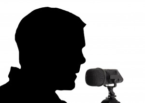 shadow figure head speaking into a microphone