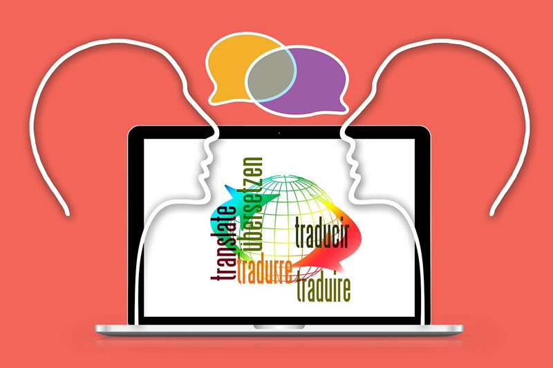 Laptop screen with globe and several languages superimposed with outlines of human heads and word bubbles for our article on types of interpreters
